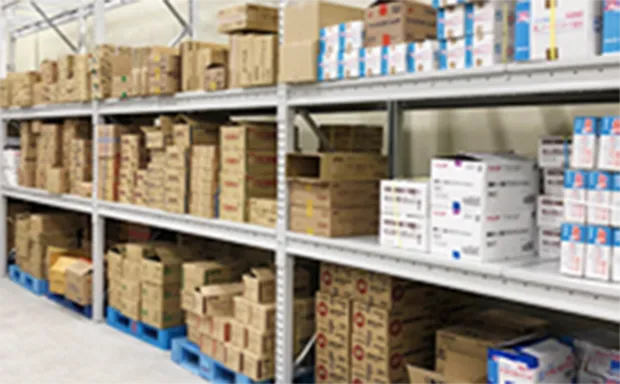 大きな倉庫の中に、箱が満載された棚が並んでいる様子